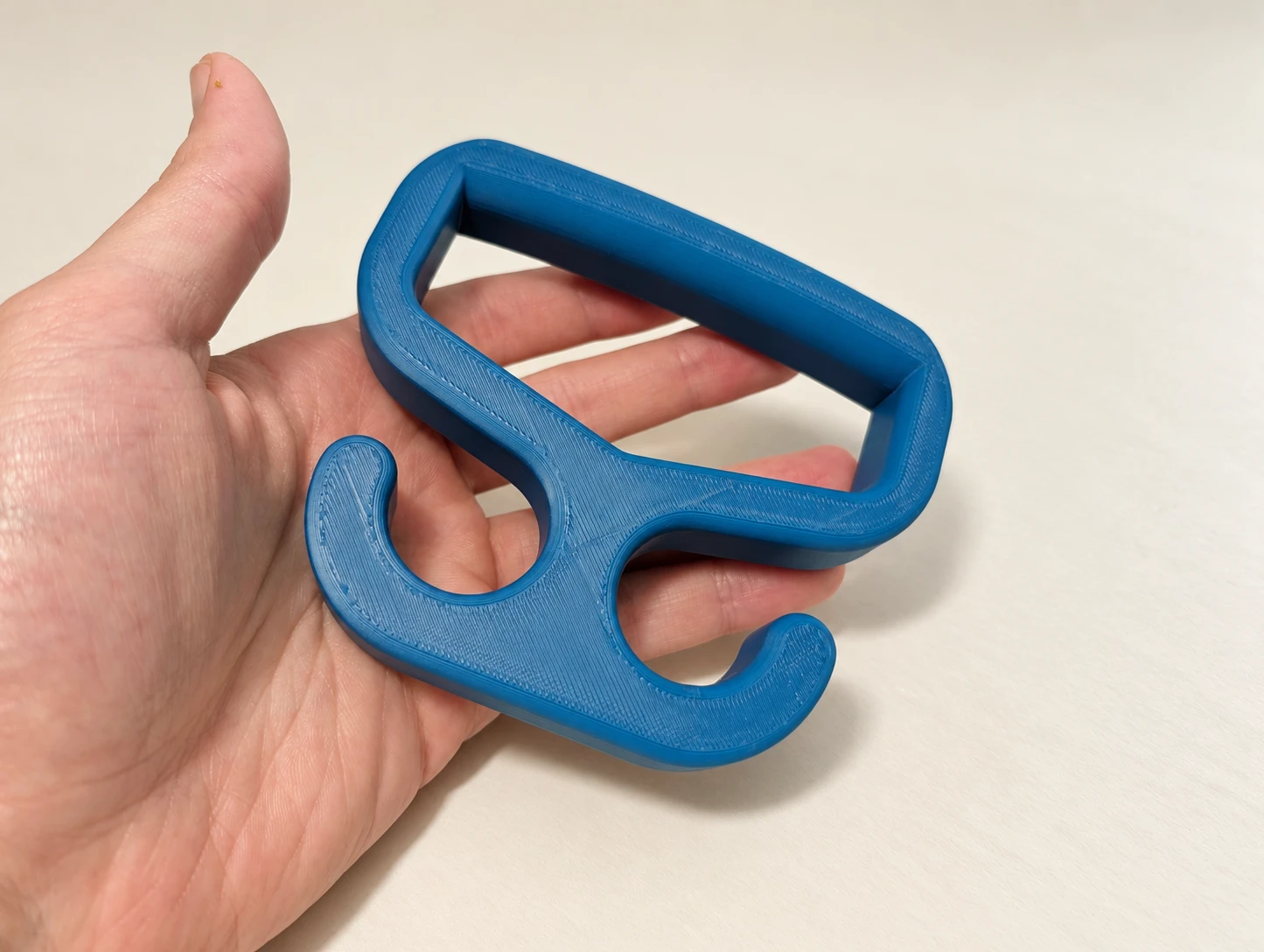 Blue 3D printed Bag Carrier shown in hand